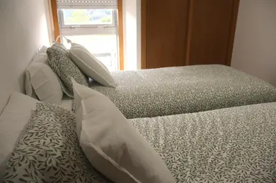 two beds sitting next to each other in a bedroom at Casa do Balneario in Arnoia