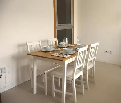 a dining room table with white chairs and a wooden table at Casa do Balneario in Arnoia