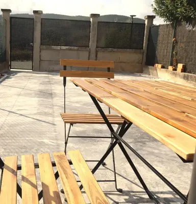 a wooden picnic table and bench on a patio at Casa do Balneario in Arnoia