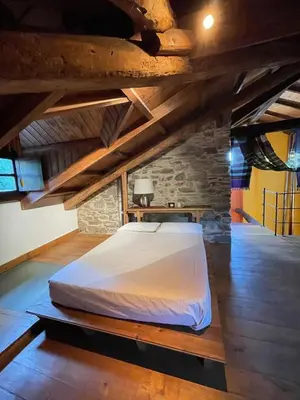a large bed in a room with wooden ceilings at La Brisa Del Bierzo in Toral de Merayo
