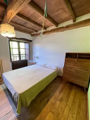 a bedroom with a large bed and a wooden floor at La Brisa Del Bierzo in Toral de Merayo