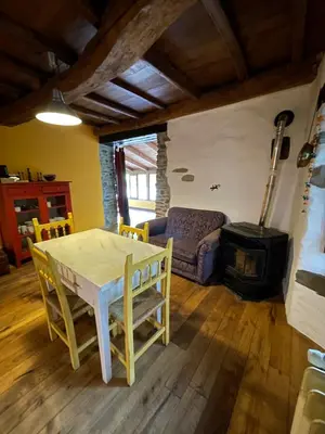 a living room with a table and a stove at La Brisa Del Bierzo in Toral de Merayo