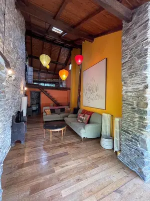 a living room with a couch and a stone wall at La Brisa Del Bierzo in Toral de Merayo