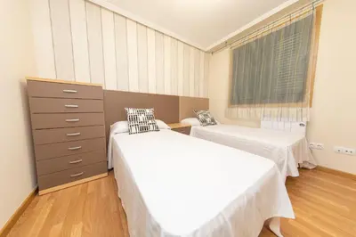 a bedroom with two beds and a dresser at Apartagal-Urbanización Foz II in Foz