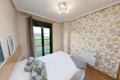 a bedroom with a white bed and a window at Apartagal-Urbanización Foz II in Foz