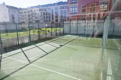 a tennis court with a tennis player on it at Apartagal-Urbanización Foz II in Foz