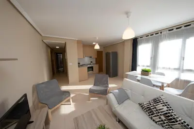 a living room with a white couch and chairs at Apartagal-Urbanización Foz II in Foz