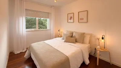a white bedroom with a large bed and a window at VIVIENDA OLGA, piso tranquilo con parking a 10 min de Santiago in Sigüeiro