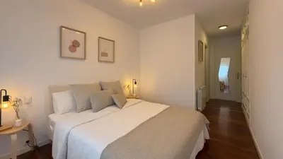a bedroom with a large white bed in a room at VIVIENDA OLGA, piso tranquilo con parking a 10 min de Santiago in Sigüeiro
