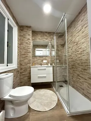 a bathroom with a toilet and a glass shower at Apartamento en el casco historico in Ourense