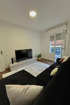 a living room with a couch and a flat screen tv at Apartamento en el casco historico in Ourense