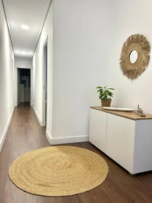 a hallway with a rug on the floor and a mirror at Apartamento en el casco historico in Ourense