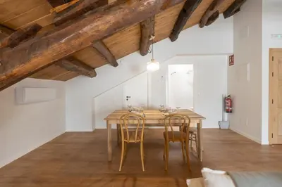 a dining room with a wooden table and chairs at Apartamentos Rurales Casa Carlota in Vegadeo