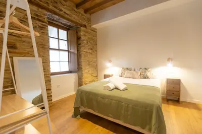 a bedroom with a bed and a ladder in it at Apartamentos Rurales Casa Carlota in Vegadeo