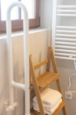 a wooden ladder in a bathroom with a pile of towels at Apartamentos Rurales Casa Carlota in Vegadeo