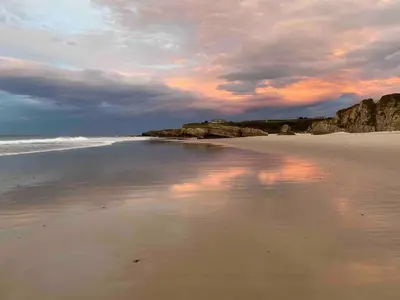 a beach with a cloudy sky and the ocean at Casa El Reposo in Barreiros