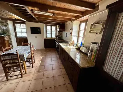 a large kitchen with a table and a counter top at Casa El Reposo in Barreiros