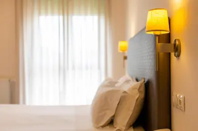 a bedroom with a bed with a lamp and a window at Hotel O Cabazo in Ribadeo