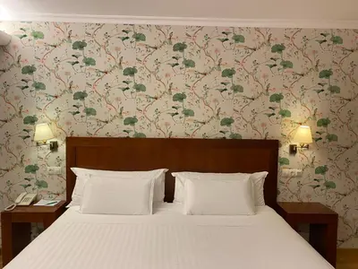 a bedroom with a bed with a floral wallpaper at Hotel O Cabazo in Ribadeo