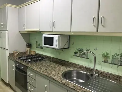 a kitchen with a sink and a microwave at Apartamento cerca de la playa in Viveiro