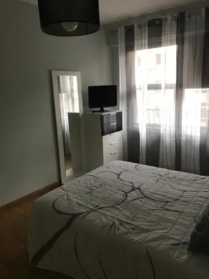 a bedroom with a bed and a tv and a window at Apartamento cerca de la playa in Viveiro