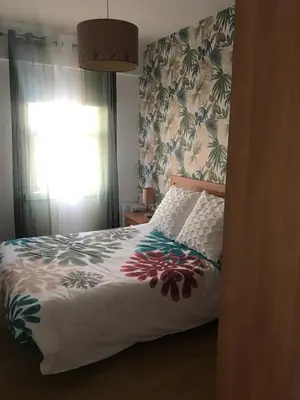 a bedroom with a bed and a window with a floral wallpaper at Apartamento cerca de la playa in Viveiro