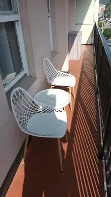 two chairs and a table on a balcony at Apartamento cerca de la playa in Viveiro