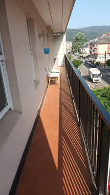 a balcony with two chairs and a view of a street at Apartamento cerca de la playa in Viveiro
