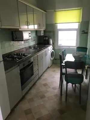 a kitchen with a table and a sink and a stove at Apartamento cerca de la playa in Viveiro