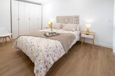 a bedroom with a bed and a table with flowers on it at Nataly,s House in Tapia de Casariego