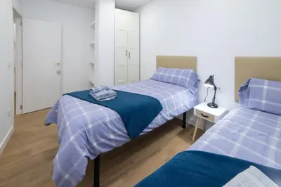 two beds in a room with blue and white at Nataly,s House in Tapia de Casariego