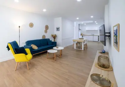 a living room with a blue couch and a yellow chair at Nataly,s House in Tapia de Casariego