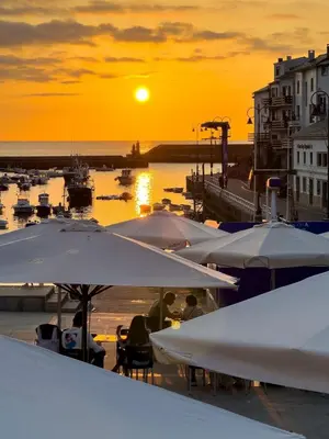 a group of umbrellas at a marina at sunset at Nataly,s House in Tapia de Casariego