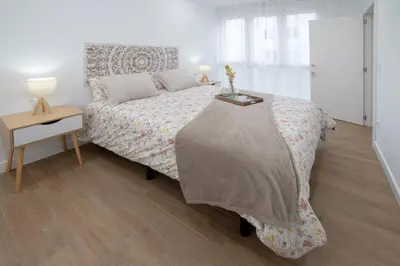 a bedroom with a bed and a night stand with a table at Nataly,s House in Tapia de Casariego