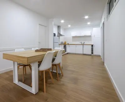 a kitchen and dining room with a wooden table and chairs at Nataly,s House in Tapia de Casariego