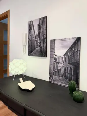 a table with a chair and two pictures on the wall at A Gandarela in Ribadavia