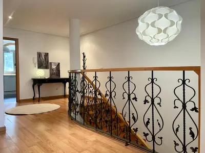 a staircase with a wrought iron railing in a living room at A Gandarela in Ribadavia