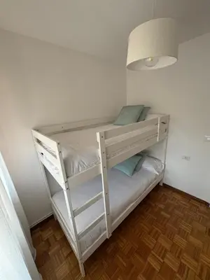 a large bed in a bedroom with two chairs at Dúplex Carballiño in Carballino