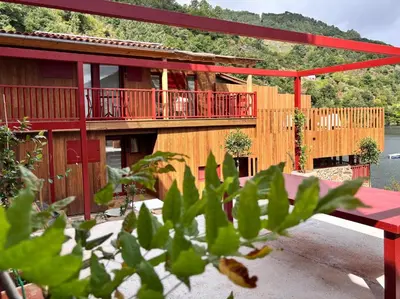 a house with a red deck and a building at Pincelo Nature in Pincelo