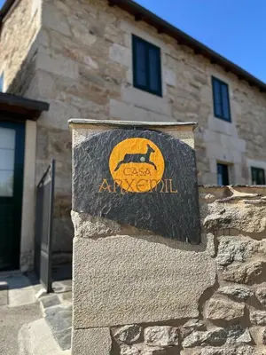 a sign on a stone wall in front of a building at Casa Arxemil in Sarria