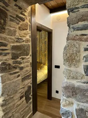a room with a stone wall and a doorway at Casa Arxemil in Sarria