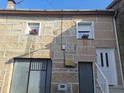 a brick building with two windows with flowers in them at Casa María in Baltar