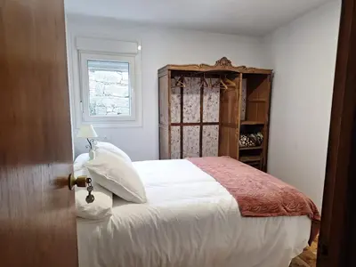 a bedroom with a white bed and a window at Casa María in Baltar