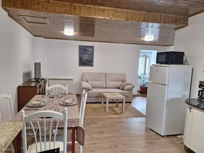 a kitchen and living room with a table and a refrigerator at Casa María in Baltar