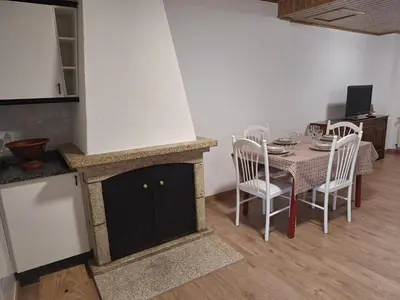 a kitchen and dining room with a table and a stove at Casa María in Baltar