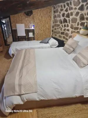 two large beds in a room with a stone wall at Oira House Jacuzzi Casa en Ourense in Ourense