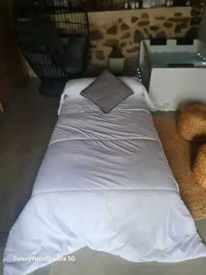 a large white bed with a pillow on the floor at Oira House Jacuzzi Casa en Ourense in Ourense