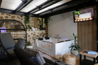 a living room with a large bathtub and chairs at Oira House Jacuzzi Casa en Ourense in Ourense