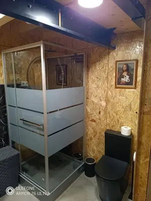 a bathroom with a glass cabinet and a toilet at Oira House Jacuzzi Casa en Ourense in Ourense
