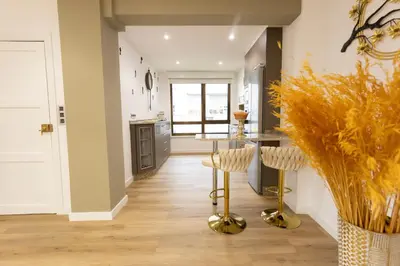 a kitchen with a table and gold stools at GemAn1 in Monforte de Lemos